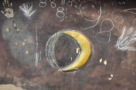 Wand mit Mond und Kreidezeichnungen