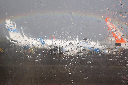 Fotografie Flieger mit Regenbogen und Regentropfen